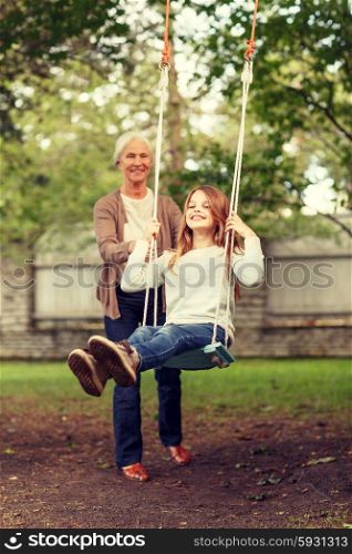 family, happiness, generation, home and people concept - happy grandmother and granddaughter swinging on teeterboard outdoors