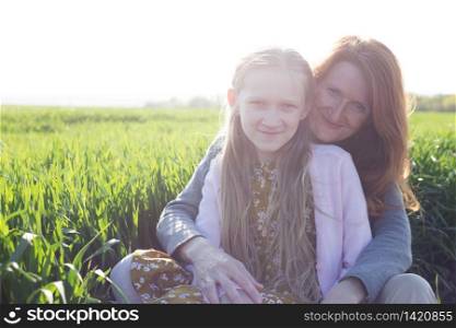 family - happy mother and daughter on a meadow