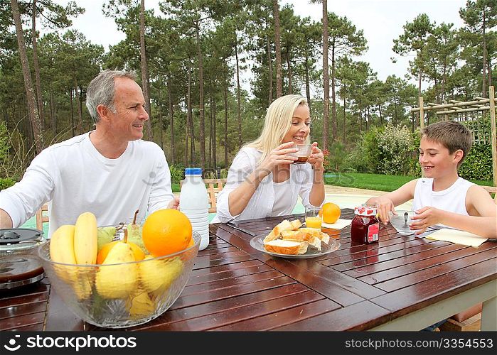 Family having breakfast in house garden