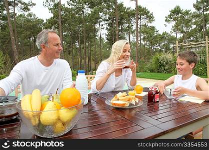 Family having breakfast in house garden
