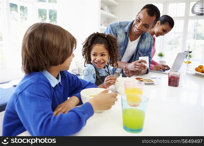 Family Having Breakfast In Kitchen Before School