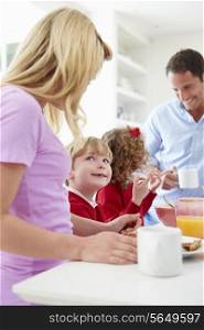 Family Having Breakfast In Kitchen Before School