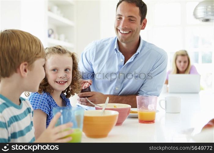 Family Having Breakfast In Kitchen Together