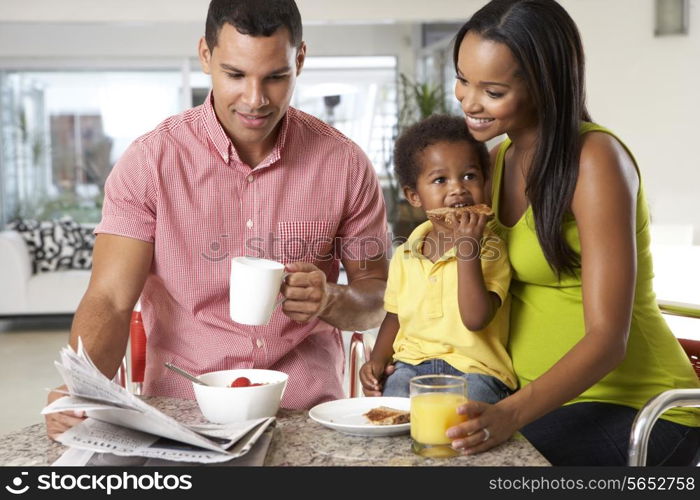 Family Having Breakfast In Kitchen Together