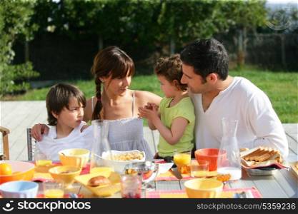 Family having brunch outside on a sunny day