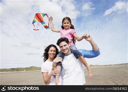 Family Having Fun Flying Kite On Beach Holiday