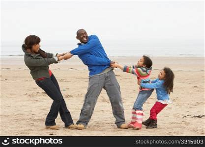 Family Having Fun On Winter Beach