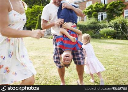 Family Having Fun Playing In Garden