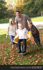 Family having fun with autumn leaves in garden