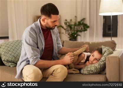family, health and people concept - father taking care of ill daughter at home. father taking care of ill daughter at home