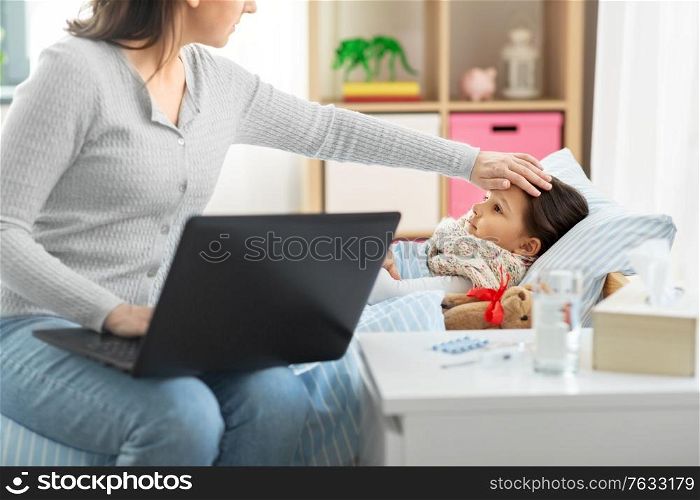 family, health and people concept - ill daughter and mother with laptop computer at home. ill daughter and mother with laptop at home