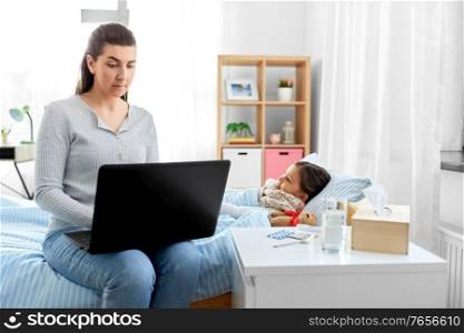 family, health and people concept - ill daughter and mother with laptop computer at home. ill daughter and mother with laptop at home