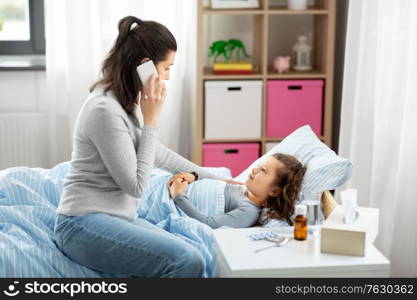 family, health and people concept - ill daughter and mother with smartphone calling doctor at home. ill daughter and mother calling on phone at home