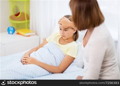 family, health and people concept - mother taking care of unhealthy daughter at home. mother taking care of unhealthy daughter at home