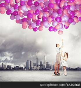 Family holding colorful balloons. Image of happy family holding bunch of colorful balloons