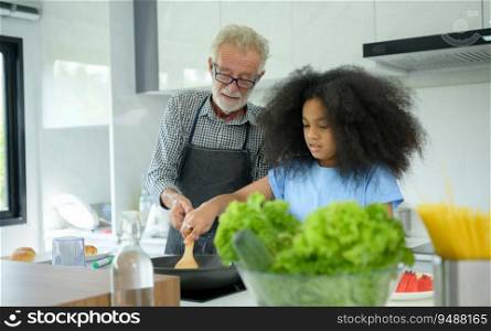 Family holiday activities with grandfather and grandchildren. Cooking dinner together for the family Grandfather is teaching cooking to his half-Asian granddaughter African American