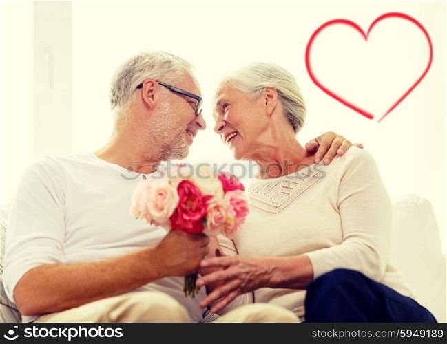 family, holidays, age and people concept - happy senior couple holding bunch of flowers at home with red heart shape