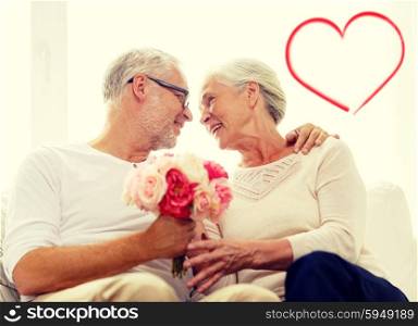 family, holidays, age and people concept - happy senior couple holding bunch of flowers at home with red heart shape