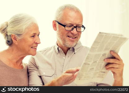 family, holidays, age and people concept - happy senior couple reading newspaper at home