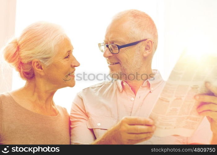 family, holidays, age and people concept - happy senior couple reading newspaper at home