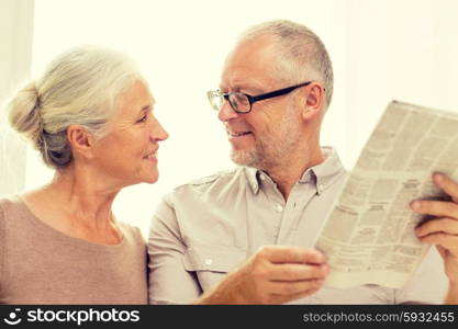 family, holidays, age and people concept - happy senior couple reading newspaper at home