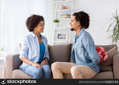 family, holidays and people concept - happy couple with bunch of flowers at home. happy couple with bunch of flowers at home