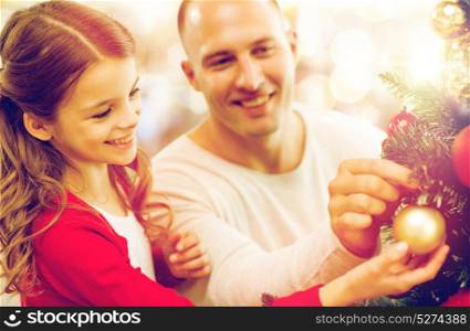 family, holidays and people concept - happy father and daughter decorating christmas tree over lights background. father and daughter decorating christmas tree