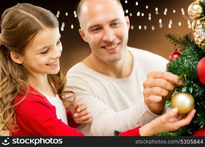 family, holidays and people concept - happy father and daughter decorating christmas tree over lights background. happy family decorating christmas tree at home