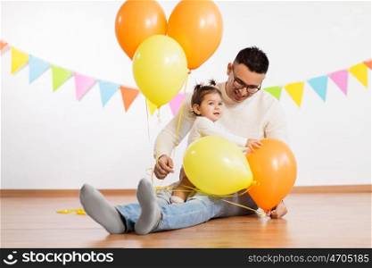 family, holidays and people concept - happy father and little daughter playing with helium balloons on birthday party. father and daughter with birthday party balloons. father and daughter with birthday party balloons