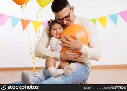 family, holidays and people concept - happy father and little daughter playing with helium balloons on birthday party. father and daughter with birthday party balloons. father and daughter with birthday party balloons