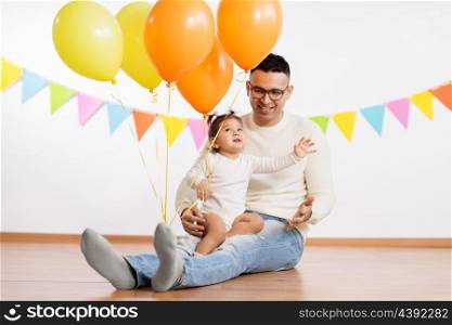 family, holidays and people concept - happy father and little daughter with helium balloons on birthday party. father and daughter with birthday party balloons. father and daughter with birthday party balloons