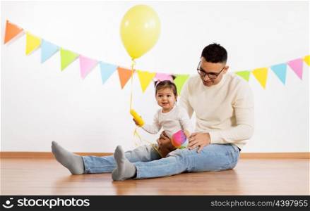 family, holidays and people concept - happy father and little daughter with helium balloon and toy ball on birthday party. father and daughter with birthday party balloon. father and daughter with birthday party balloon