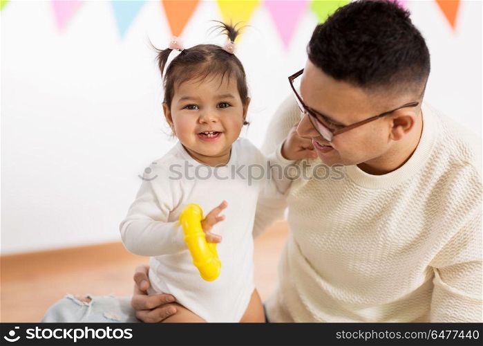 family, holidays and people concept - happy father and little daughter with helium balloon on birthday party. happy father and little daughter at birthday party. happy father and little daughter at birthday party