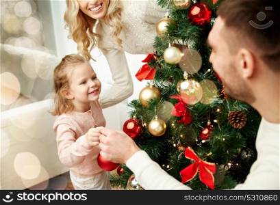 family, holidays and people concept - happy mother, father and little daughter decorating christmas tree over lights background. happy family decorating christmas tree