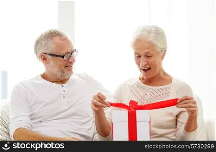 family, holidays, christmas, age and people concept - happy senior couple with gift box at home
