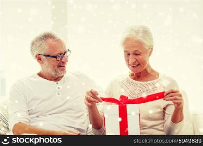 family, holidays, christmas, age and people concept - happy senior couple with gift box at home