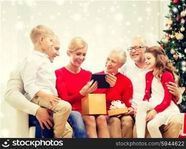 family, holidays, christmas, technology and people concept - smiling family with gift box and tablet pc computer sitting on couch at home