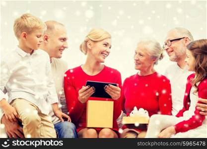 family, holidays, christmas, technology and people concept - smiling family with gift box and tablet pc computer sitting on couch at home