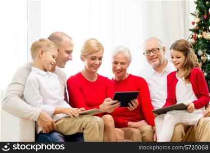 family, holidays, christmas, technology and people concept - smiling family with tablet pc computers sitting on couch at home