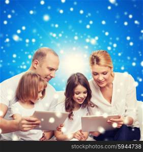 family, holidays, christmas technology and people - smiling mother, father and little girls with tablet pc computers over blue snowy background