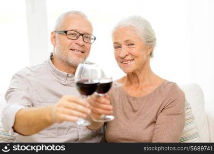 family, holidays, drinks, age and people concept - happy senior couple with glasses of red wine at home