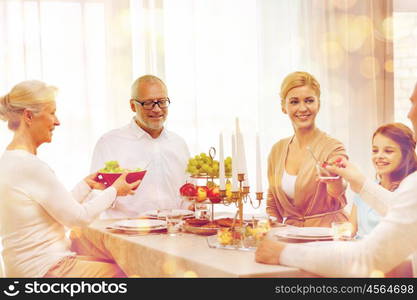 family, holidays, generation and people concept - smiling family having dinner at home