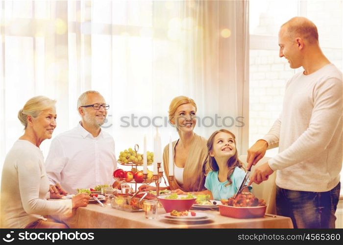 family, holidays, generation and people concept - smiling family having dinner at home