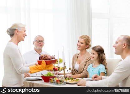 family, holidays, generation and people concept - smiling family having dinner at home