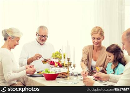 family, holidays, generation and people concept - smiling family having dinner at home