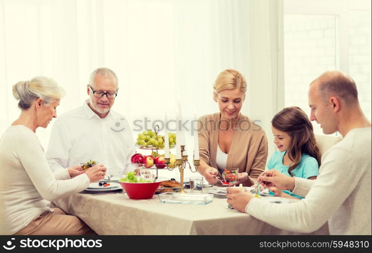 family, holidays, generation and people concept - smiling family having dinner at home