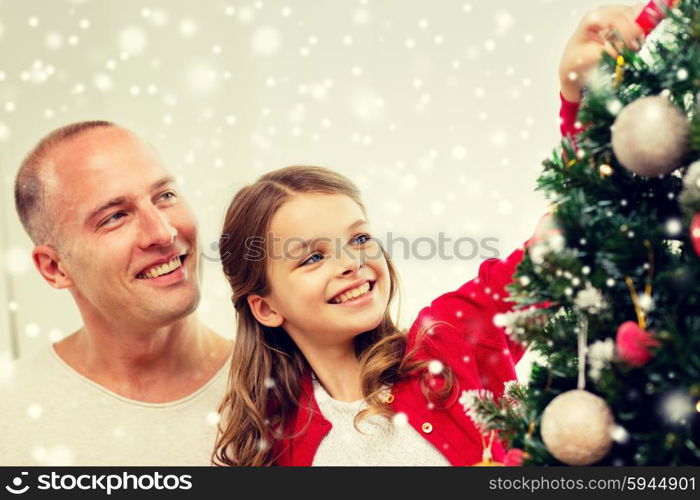 family, holidays, generation and people concept - smiling girl with father decorating christmas tree at home