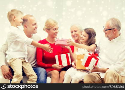 family, holidays, generation, christmas and people concept - smiling family giving each other presents at home