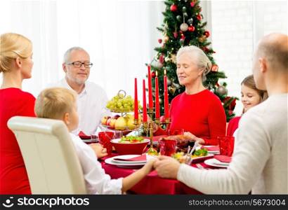 family, holidays, generation, christmas and people concept - smiling family having dinner and praying at home