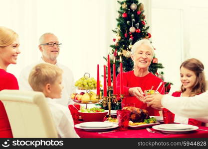 family, holidays, generation, christmas and people concept - smiling family having dinner at home